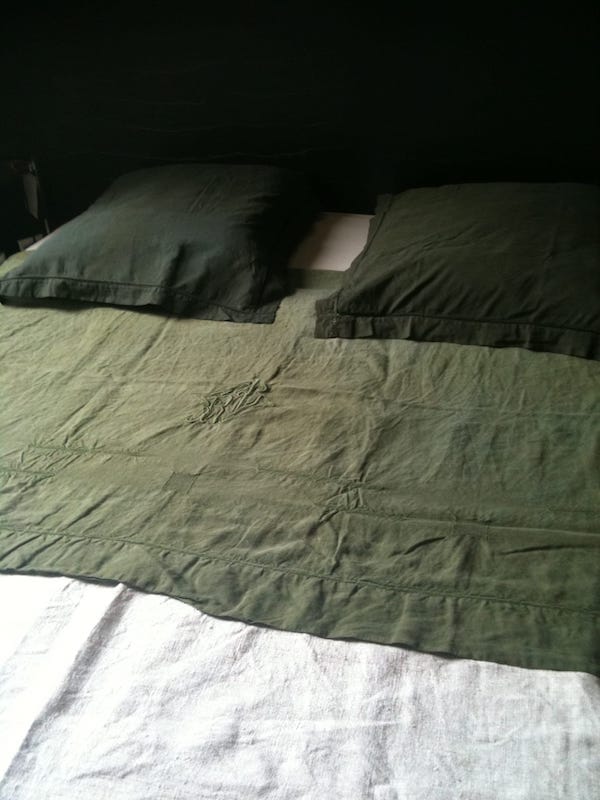 drap en lin vert kaki avec un drap en chanvre en guise de couvre lit