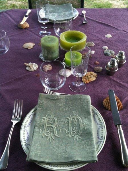 table avec nappe en damassé de lin prune et serviettes en lin kaki vaisselle en faïence et couverts en métal argenté