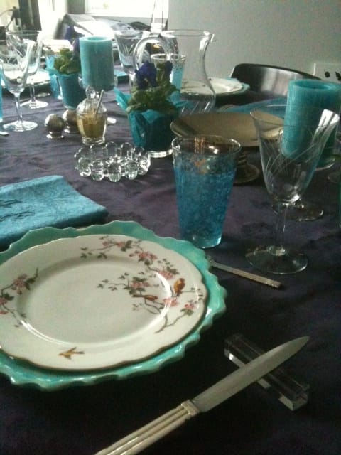 table réalisée avec une nappe mûre et des serviettes turquoises un mélange de vaisselle contemporaine et ancienne